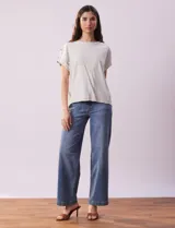 Blusa de lino color blanco con rayas verticales, de la marca Cable & Gauge. Tiene hombros con aplique de botones.