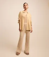 Camisa color beige de viscolino con cuello camisero, manga larga, botonadura frontal y corte holgado.
