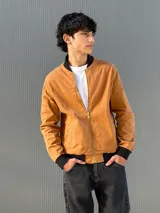 Campera bomber de gabardina color tostado, con cierre frontal y ribetes en negro.
