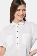 Camisa de lino color beige, de manga corta, con medio botón, dos bolsillos en el pecho y botones metálicos personalizados.