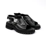 Sandalia de cuero vacuno color negro, con suela de goma deportiva, hebilla al tobillo y horma ancha.