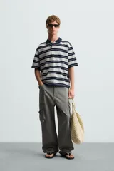 Polo de hombre corte holgado con cuello solapa y cierre de botones. Diseño a rayas horizontales grises y azul marino.