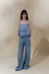 Pantalón de jean azul de pierna ancha y tiro medio, con cinco bolsillos y pespuntes a contratono.