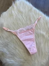 Tanga rosada de algodón con encaje en la parte delantera y tiras regulables.
