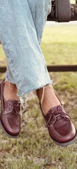 Mocasines náuticos color borgoña de cuero con cordones y suela marrón.