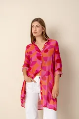 Camisa larga con estampado geométrico en tonos fucsia, naranja y rojo.