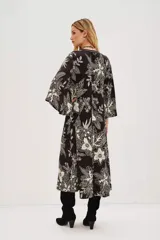 Vestido largo negro con estampado floral en color crema, escote en V y mangas acampanadas.