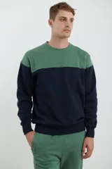 Sweater deportivo color beige con corte colorblock azul marino en el pecho y puños elastizados.