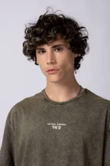 Remera negra con efecto gastado, corte holgado y estampa frontal con la frase 'Astral Energy' en blanco.