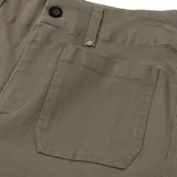 Pantalón de gabardina color verde oliva, de corte ancho y tiro alto, con bolsillos delanteros tipo parche.