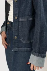 Chaqueta de jean azul oscuro con costuras blancas y lycra.