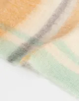 Bufanda tejida con diseño a rayas horizontales en tonos pastel, con flecos en los extremos y etiqueta de goma.