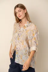 Camisa estampada con flores amarillas y lilas, de corte recto y mangas largas.
