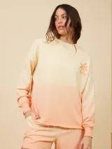Sweater color crema con degradé a naranja, con cuello redondo y logo estampado de palmera en el pecho.