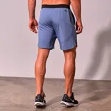 Short deportivo de hombre color celeste con cintura elástica negra, cordón de ajuste interno, bolsillos laterales y logo estampado en la pierna.