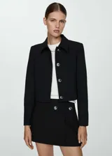 Chaqueta corta negra con cuello camisero, cierre frontal con botones plateados y mangas largas.