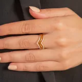 Anillo dorado con diseño de doble V invertida, con incrustaciones de circonias. Fabricado en oro 9k.