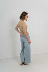 Pantalón de jean celeste claro, corte palazzo, tiro alto, bolsillos delanteros y traseros, y detalle metálico con el logo Peach en el bolsillo trasero.