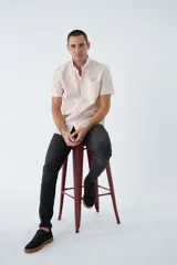 Camisa blanca de manga corta con cuello abotonado (button-down) y bolsillo en el pecho con logo bordado.