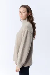 Polera beige melange de punto con cuello tortuga.