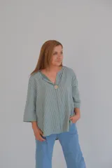 Blusa verde con rayas verticales blancas, escote en V con botón de madera y mangas 3/4.