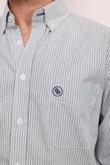 Camisa celeste con rayas verticales blancas, de corte clásico, con cuello abotonado, manga larga y bolsillo en el pecho.