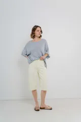 Bermuda de tiro medio color crema, con corte recto y largo a la rodilla. Diseño amplio tipo culotte corto, con dobladillo ancho en el ruedo. Presenta bolsillos delanteros y traseros funcionales.