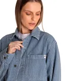 Chaqueta de mezclilla (denim) con estampado de rayas verticales blancas y azules (hickory stripe). Es de corte oversize, manga larga, cuello camisero, cierre frontal con botones y bolsillos de parche en el pecho.