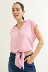 Camisa celeste con cuello, abotonada al frente y mangas cortas.