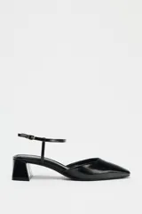 Zapato destalonado acharolado negro, con punta cuadrada, tacón ancho y pulsera al tobillo con hebilla.