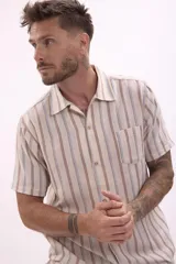 Camisa de manga corta con estampado a rayas verticales en tonos beige, marrón y celeste.