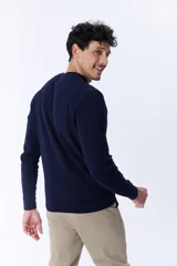 Buzo azul marino de punto con textura acanalada y cuello redondo.