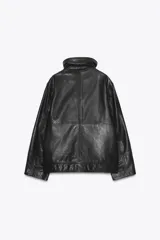 Cazadora bomber de cuero color marrón, con cuello alto, manga larga y bolsillos de parche con solapa en el delantero. Cierre frontal con cremallera metálica y botones a presión ocultos por solapa.