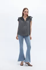 Blusa blanca de lyocell y algodón, con escote fruncido con volados y lazos.