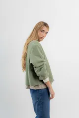 Chaqueta corta tipo blazer color marrón, confeccionada en tela de lana afieltrada. Tiene cuello camisero, silueta cuadrada, cierre frontal con botones y bolsillos delanteros.