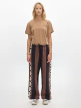 Pantalón tipo jogging con pierna ancha, cinturilla elástica y bolsillos laterales, confeccionado en 100% algodón.