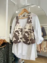 Chaleco con estampado de vaca en tonos marrones y beige, con botones al frente.