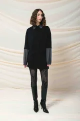 Remerón negro con cuello camisero gris, mangas largas grises con puños elásticos y bolsillo con solapa en el pecho.