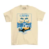 Remera color beige con un estampado gráfico inspirado en la novela "El Gran Gatsby" de F. Scott Fitzgerald. El diseño presenta una mansión estilo art déco, un coche amarillo clásico y unos ojos con anteojos en la parte superior.