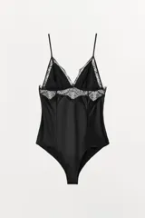 Body negro de tejido satinado con escote en pico y encaje a tono. Tirantes finos ajustables y cierre inferior con botones a presión.