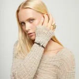 Pulsera ajustable con cordón de cuero marrón y un dije central de corazón plateado con acabado martillado. Cuenta con un cierre corredizo de bola metálica plateada.