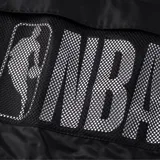 Campera negra con capucha y cierre frontal. Tiene un bolsillo de red en el pecho y el logo de la NBA en la manga.