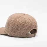 Gorra de seis paneles con corona de textura tipo borreguillo y visera lisa. Incluye cierre ajustable con hebilla engomada en la parte posterior.