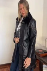 Tapado largo de cuero negro con cuello de piel sintética desmontable y detalles de pasamanería marrón vintage en hombros y espalda. Se convierte en abrigo corto mediante un cierre.