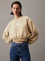 Buzo cropped de felpa en color beige, con cuello redondo y puños elásticos, decorado con insignia de Calvin Klein.