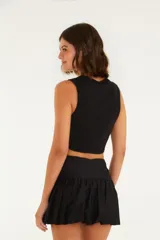 Top color beige, corte crop, con escote redondo y tirantes anchos.