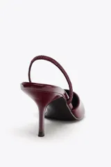 Zapato destalonado color beige acharolado, con escote en pico, tira trasera ajustable y tacón fino.