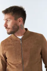 Campera marrón de gamuza para hombre, con cuello mao, cierre frontal con cremallera, bolsillos laterales y puños ajustados.