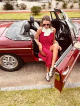 Vestido de fiesta fucsia con escote y espalda de cuero, tajos laterales con hilo metálico y terminación con flecos.