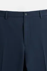 Pantalón de vestir negro slim fit, confeccionado en tejido con viscosa. Cuenta con bolsillos frontales y traseros de vivo. El cierre es frontal con cremallera y botón.